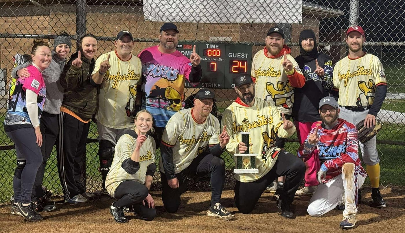 The Impastas holding the league championship trophy in their cream and gold jerseys