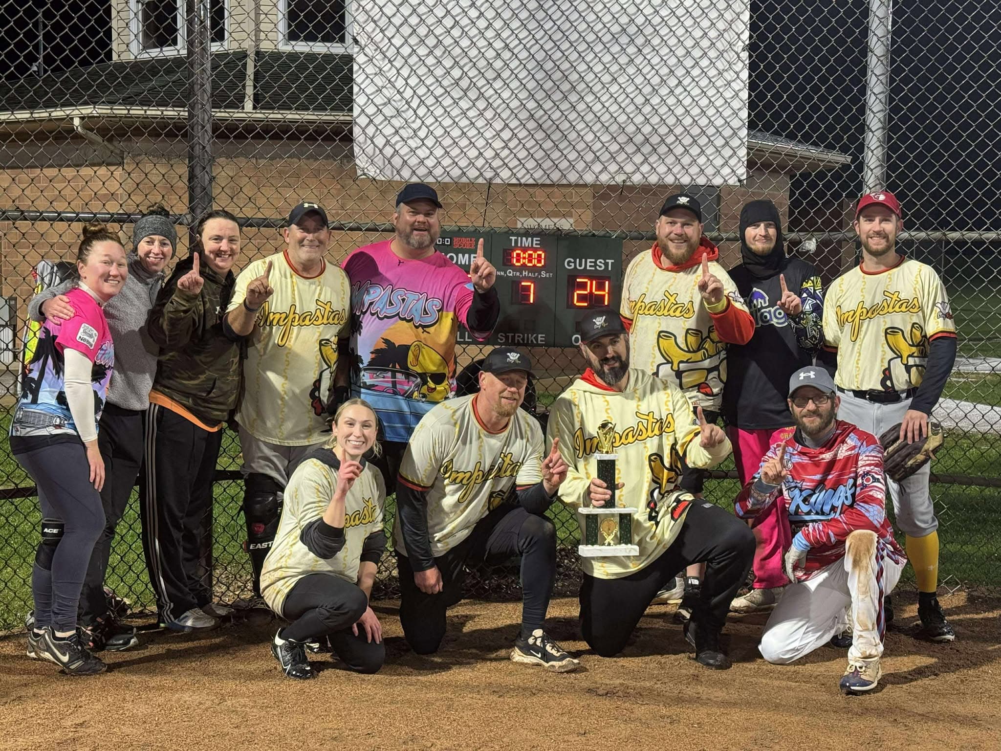The Impastas holding the league championship trophy in their cream and gold jerseys