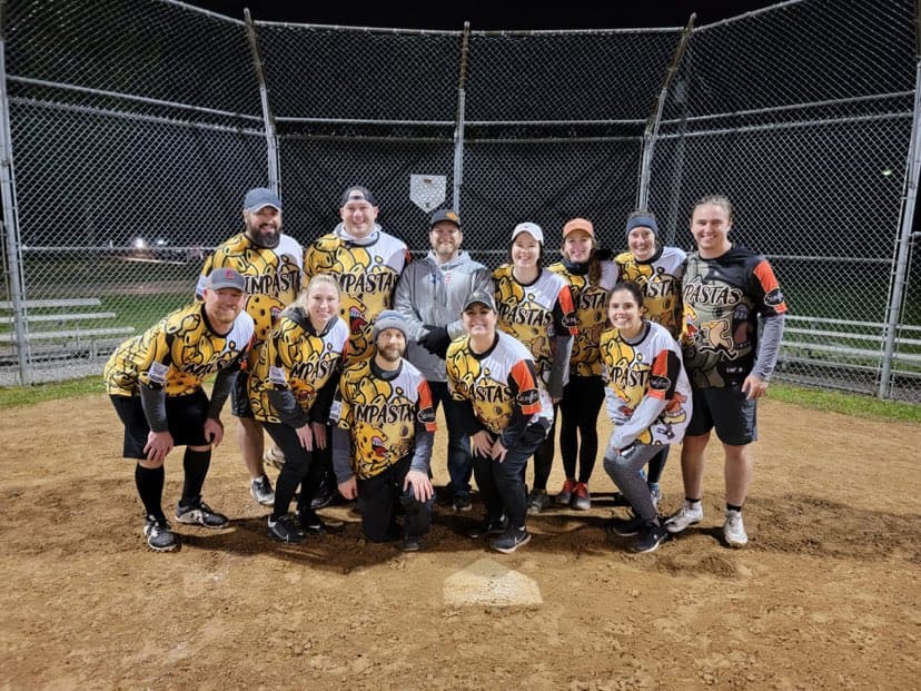The year one team at home plate under the lights in gold and black jerseys